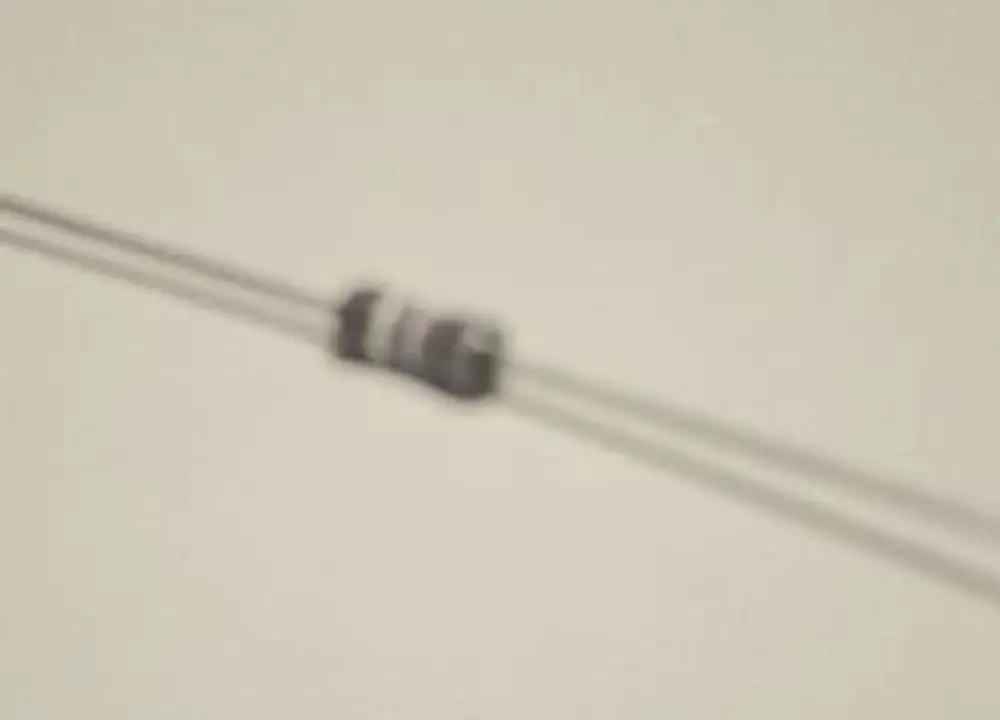 Widerstand auf einem Kabel platziert, mit der Marke Remeha, unscharf abgebildet. Der Widerstand scheint in der Mitte des Bildes zu liegen.